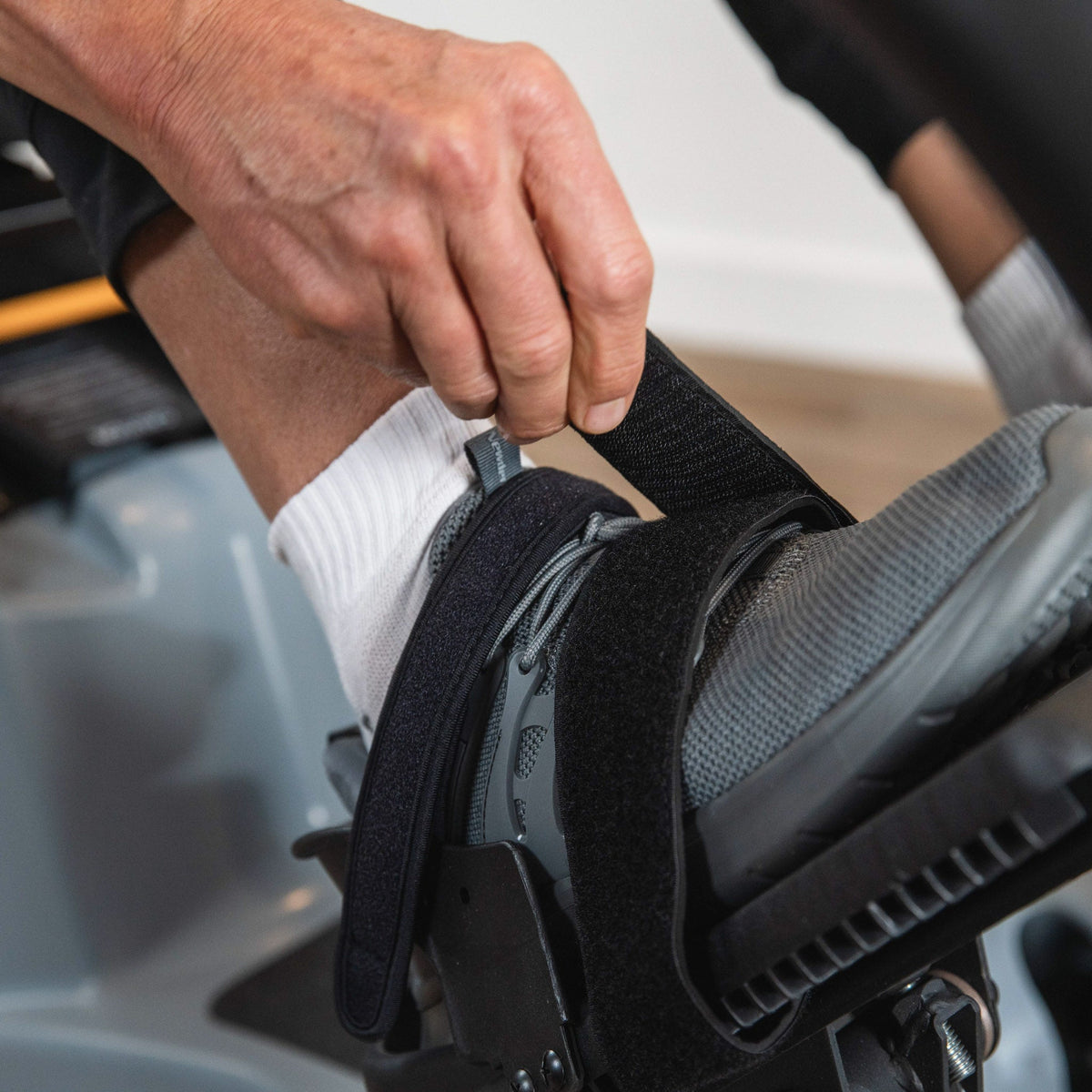 Hand fastening a pedal strap over a shoe on the LXT-700.