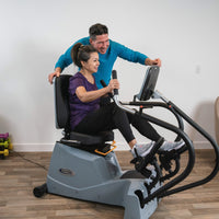 Woman using the LXT-700 while another person stands beside the console.