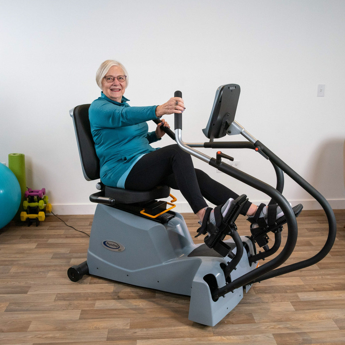 Woman seated on the LXT-700 using the moving handles and pedals.