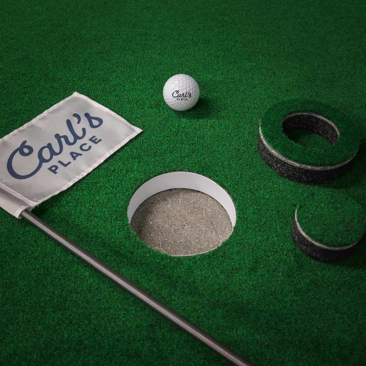 Big Moss Turf with putting hole, flag and Carl's Place golf ball