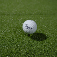 Golf ball teed up on the HotShot mat turf