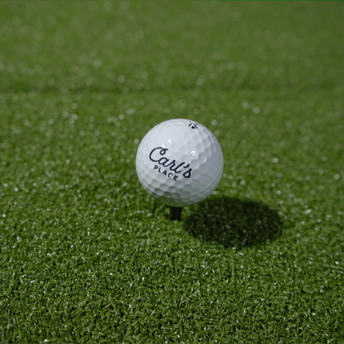Golf ball teed up on the HotShot mat turf